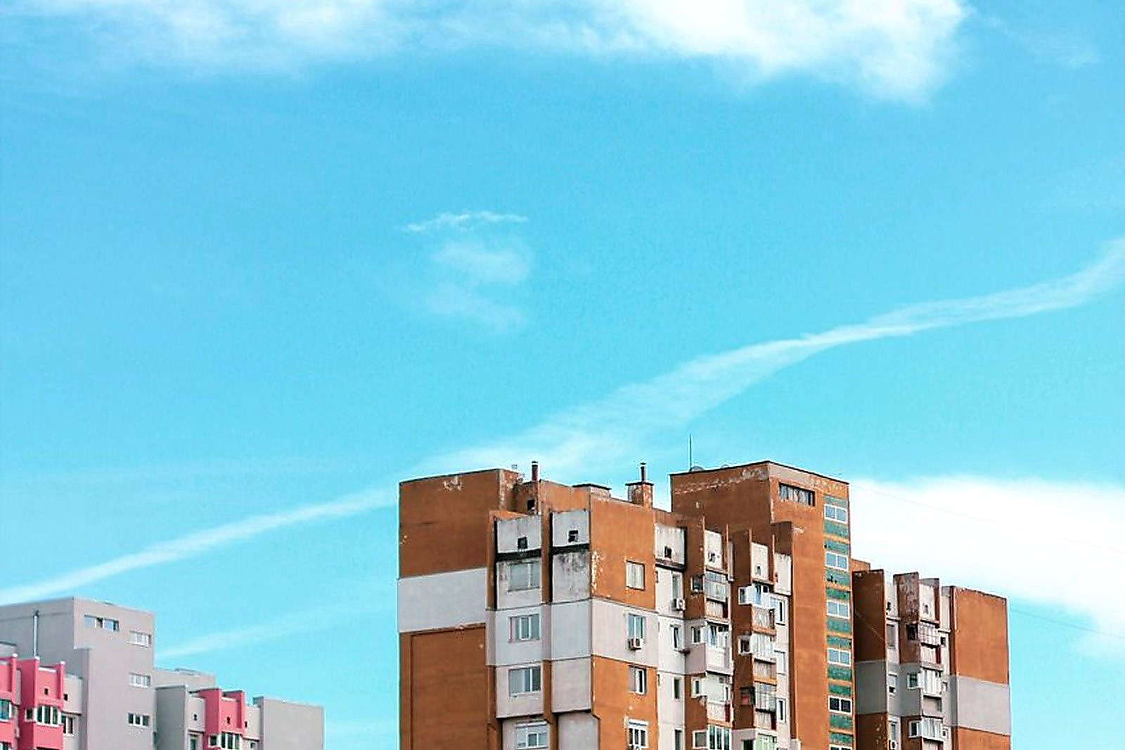 Free Colorful highrise apartment buildings under a clear blue sky on a sunny day. Stock Photo